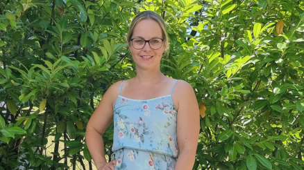 Ein Foto von Claudia vor grünen Blättern - sie berichtet um den Spagat zwischen Kinder und Job.