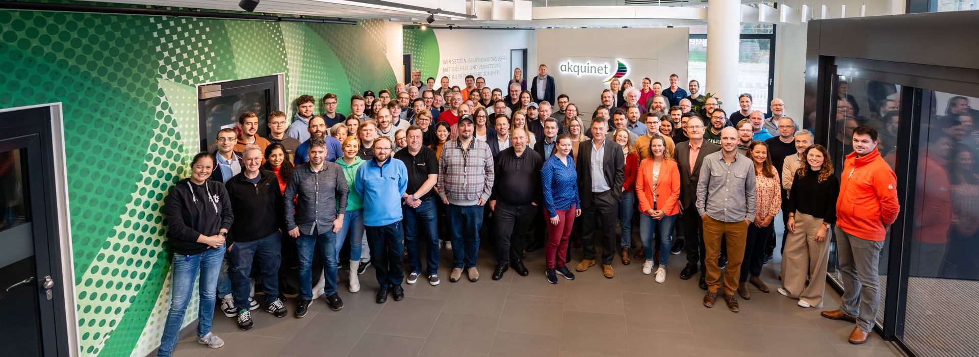 Karriere-AKQUINET: Das Team der AKQUINET im Foyer der Firmenzentrale an der Bramfelder Spitze