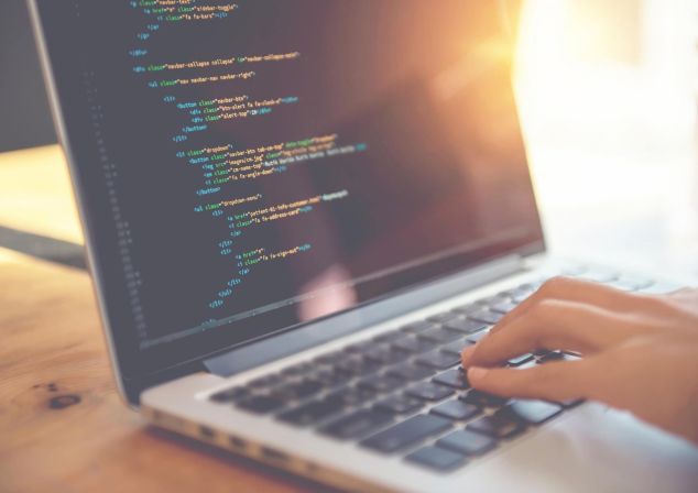 Ein Softwareentwickler von AKQUINET programmiert auf einem Laptop.